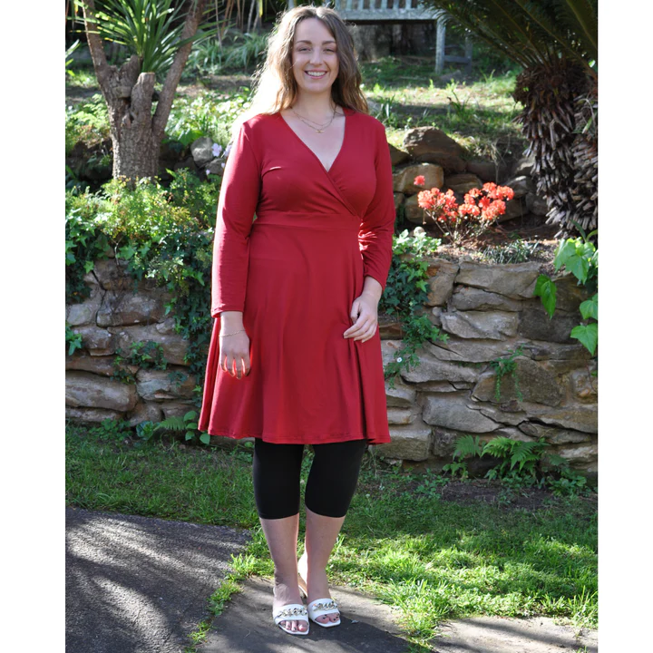 red wrap dress with a V-neck, black tights and ankle strap heels